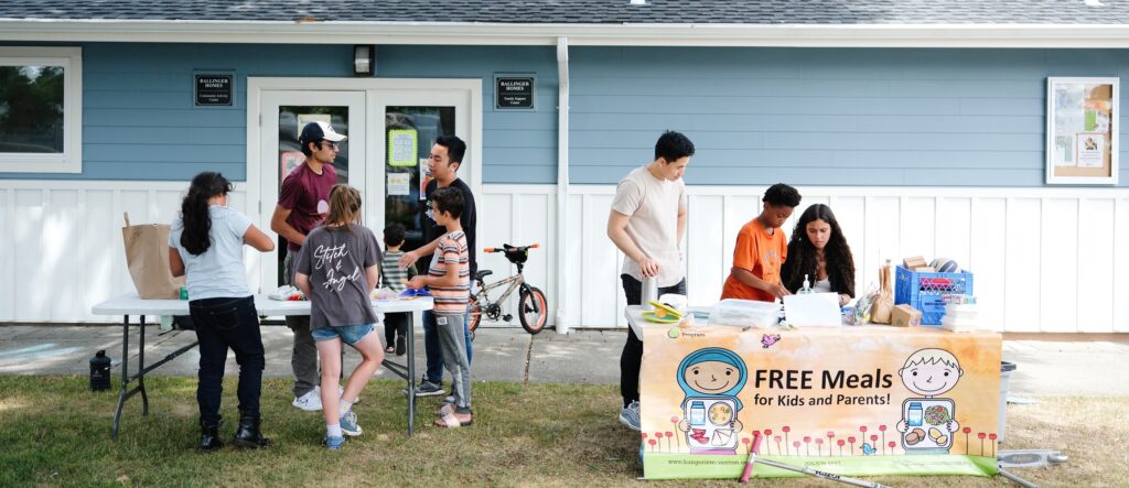 Children receiving free healthy meals and participating in fun activities at a summer meals site.